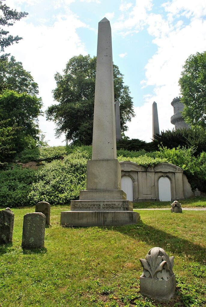 A large obelisk in a cemetery