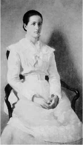 A black and white photograph of a woman seated in a white dress