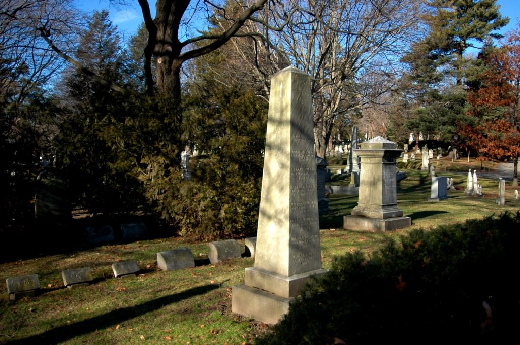 A photograph of a marble obelisk in a cemetery