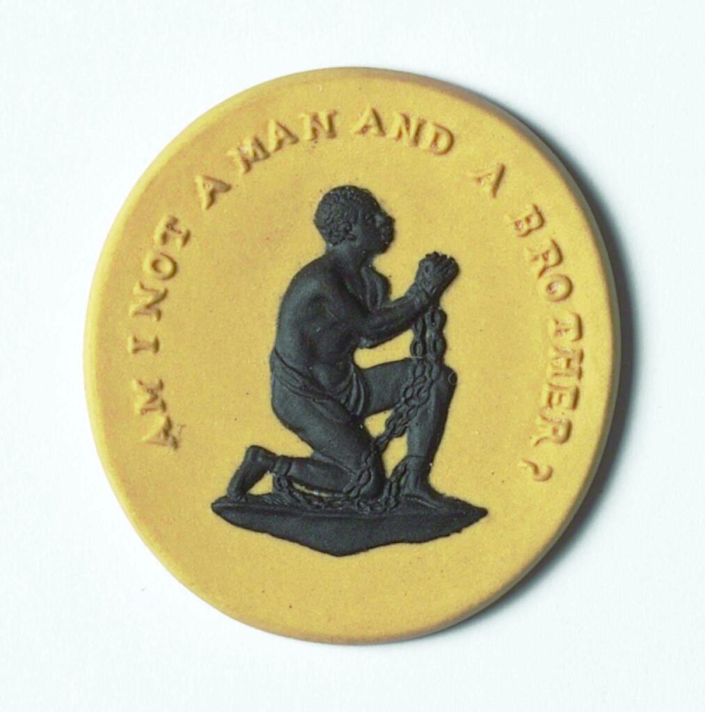 A small medallion picturing an enslaved person on their knees in chains, with text around them reading "Am I not a man and a brother?" 