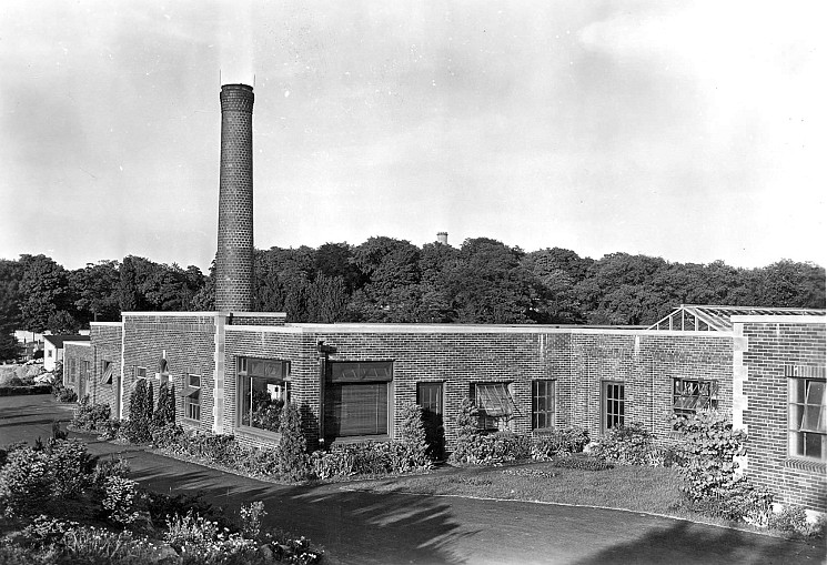 A photo of a brick building with a small smoke stack