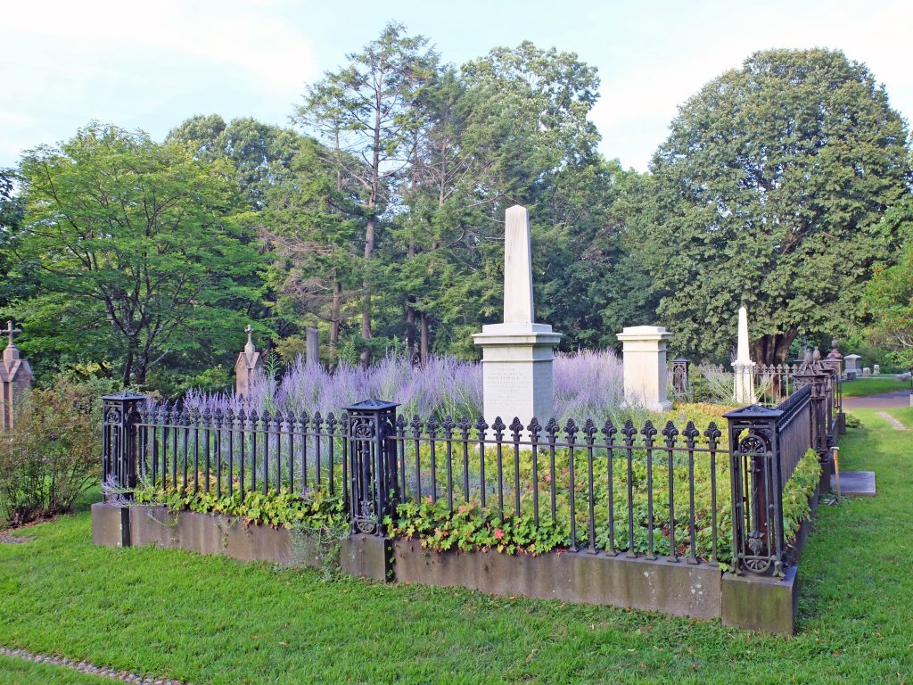 Cast iron fence surrounds cemetery monuments